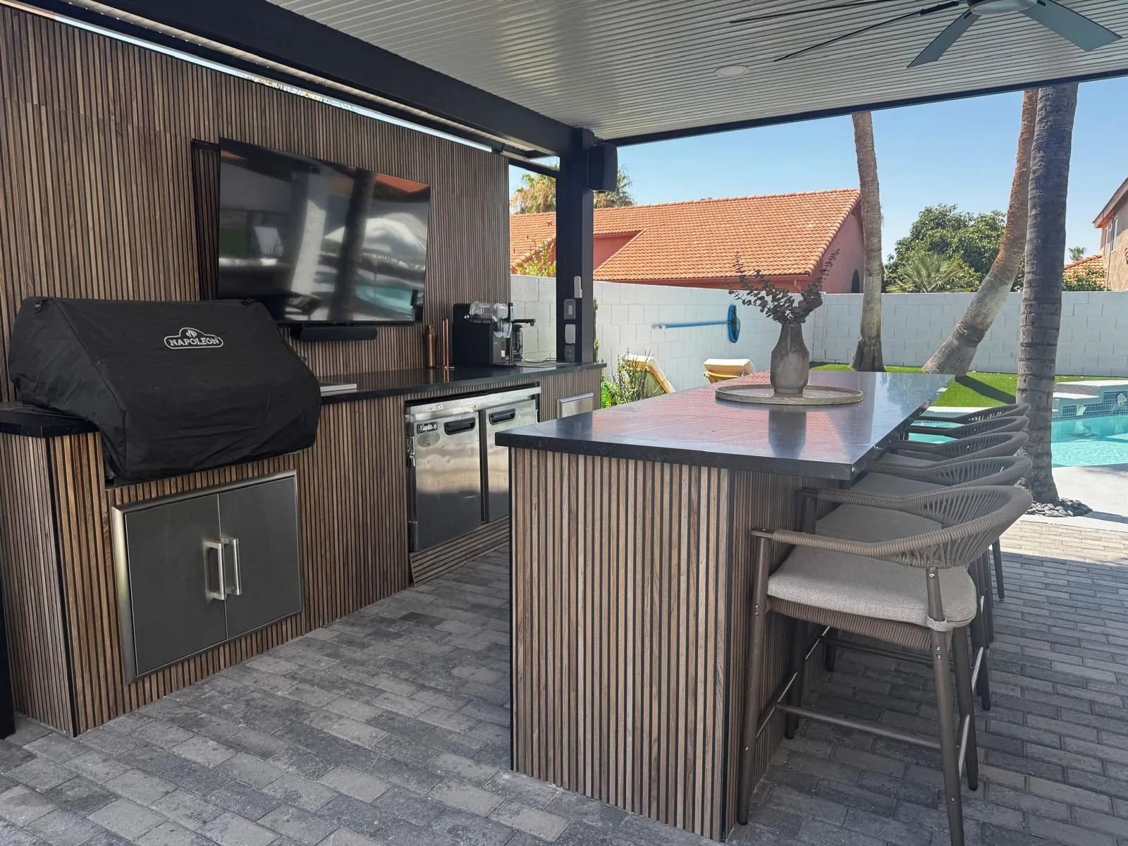 Paradise Valley, AZ backyard outdoor kitchen with a BBQ island and countertop bar by the pool, by RDC